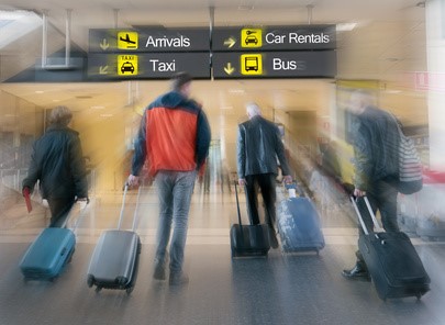 Fluggäste ziehen Ihre Rollkoffer durch das Flughafengebäude